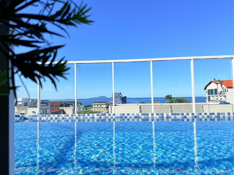 Passos da praia c/ piscina apto iluminado e novo